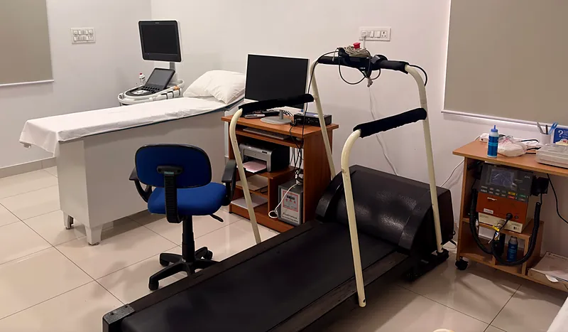 The treadmill used for stress tests, with the ECG recording system and the echo bed behind it